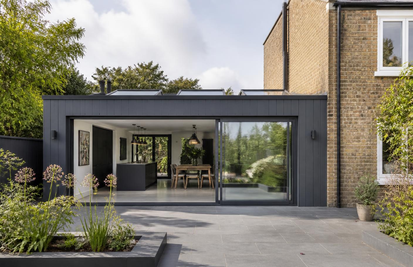 Large bespoke garden building with anthracite glazing and outdoor seating
